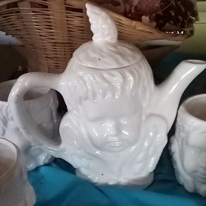 White porcelain chair of teapot with four matching mugs